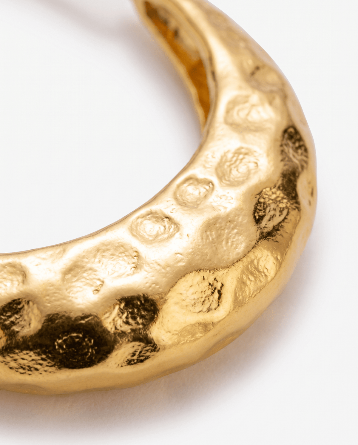 Gold hoop earrings hammered surface close-up