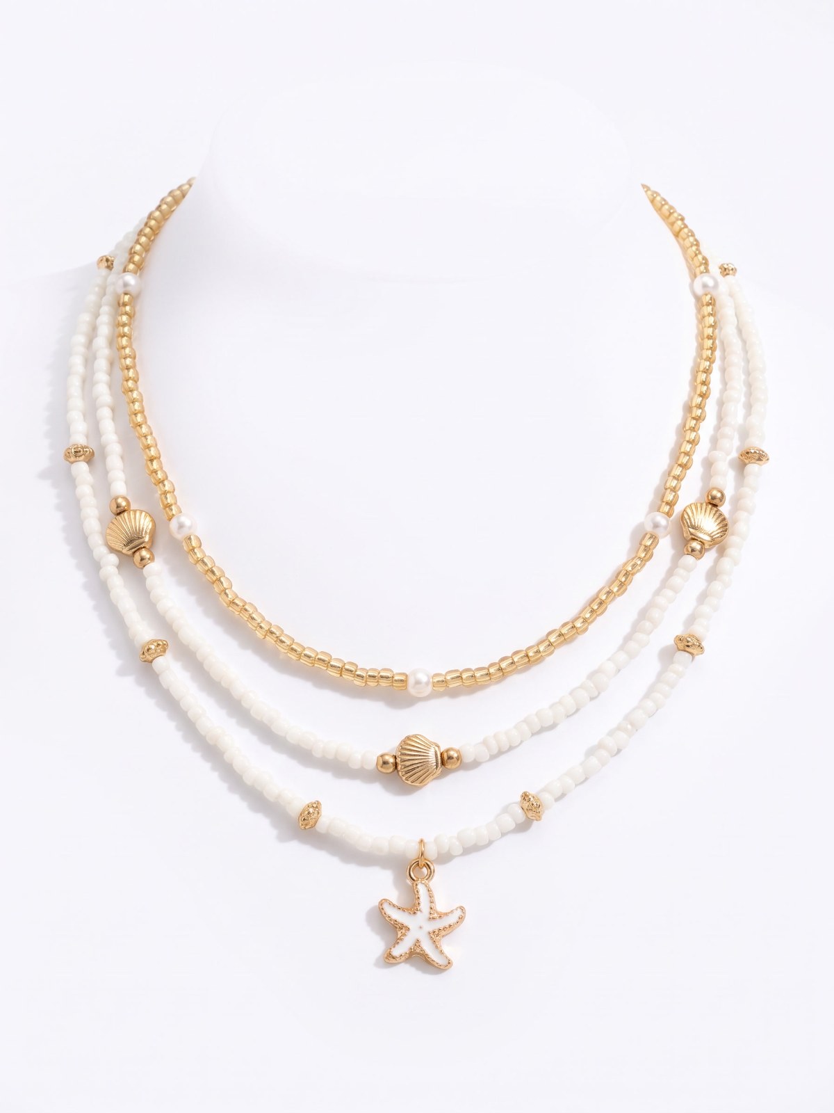 Shell and starfish layered necklace set on a white background