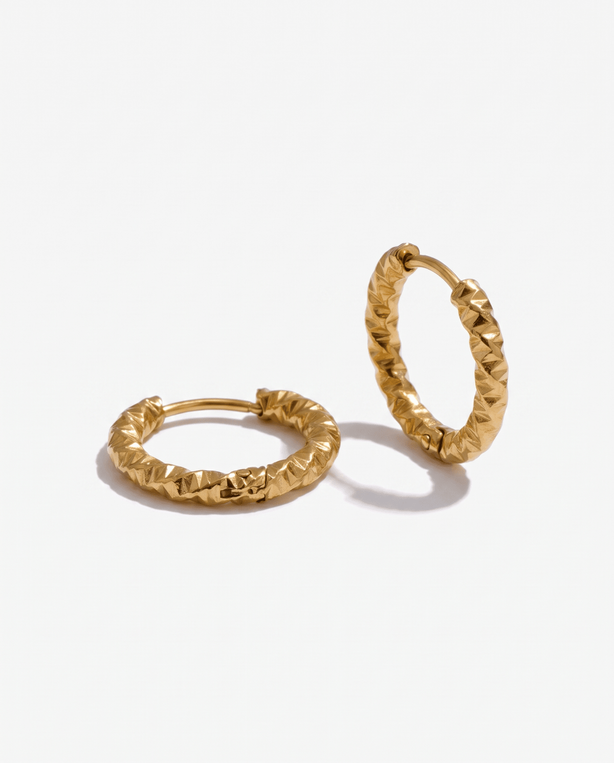 Small gold hoop earrings faceted flat lay