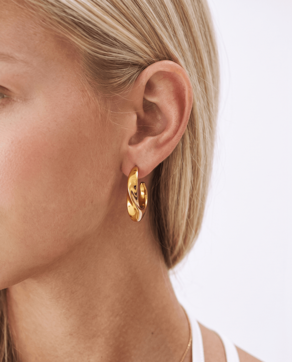 Chunky gold hoop earrings side view on model