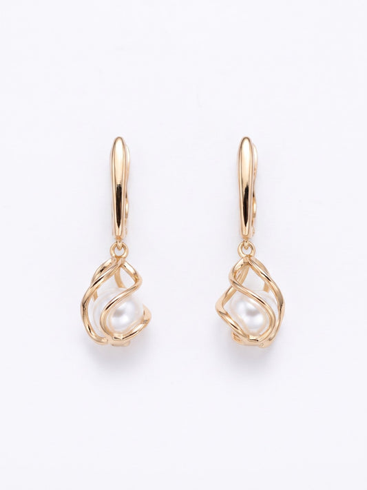 Gold drop earrings with pearl detail on a white background
