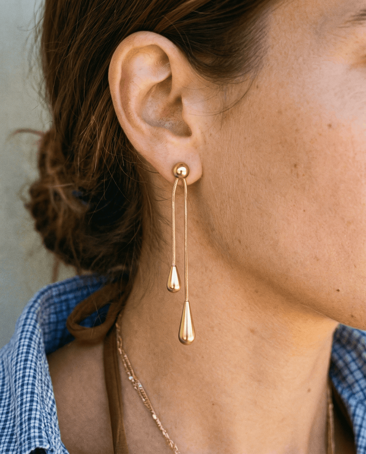 Gold-tone drop earrings with long teardrop design in Gold