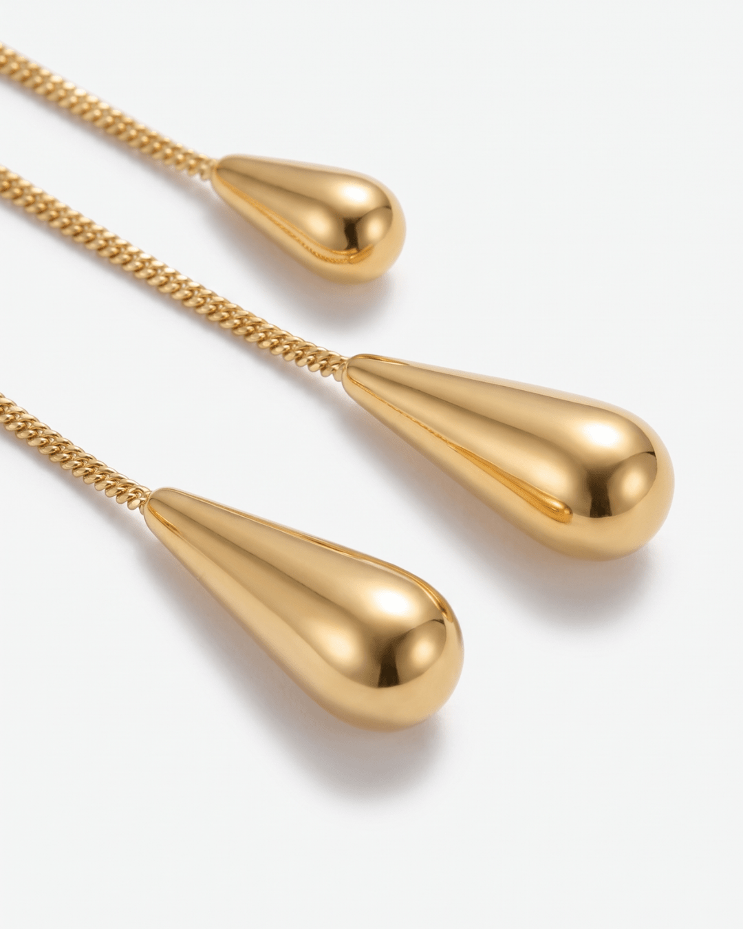 Gold-tone drop earrings with long teardrop design in Gold