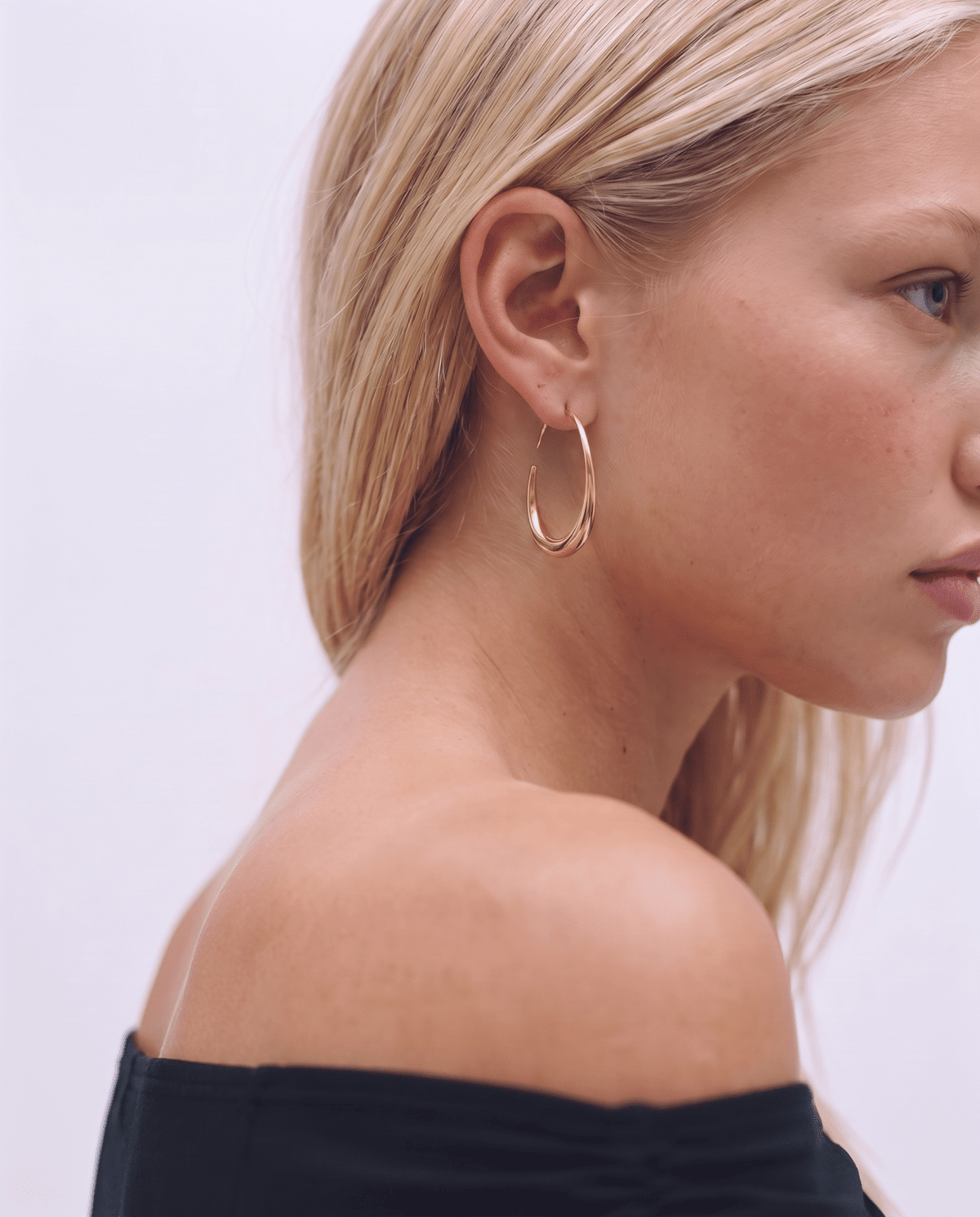 Gold-tone hoop earrings worn, elongated threader
