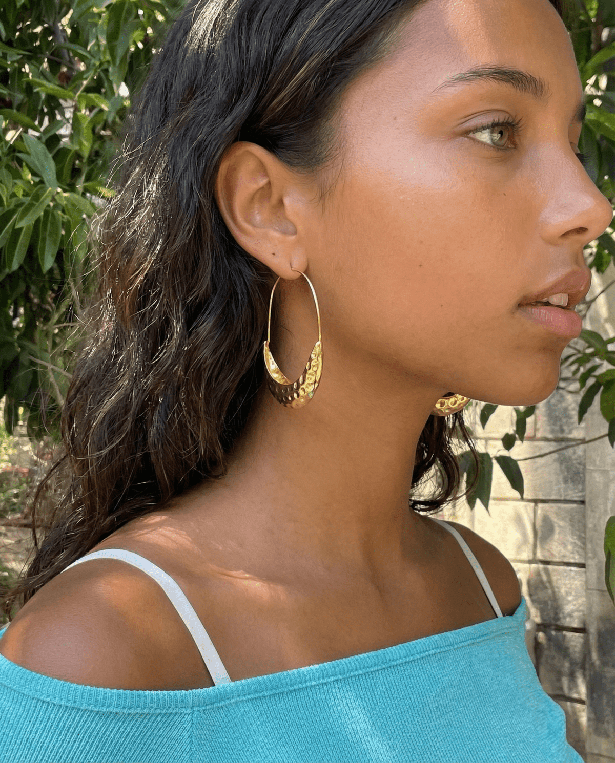 Gold hammered hoop earrings on model