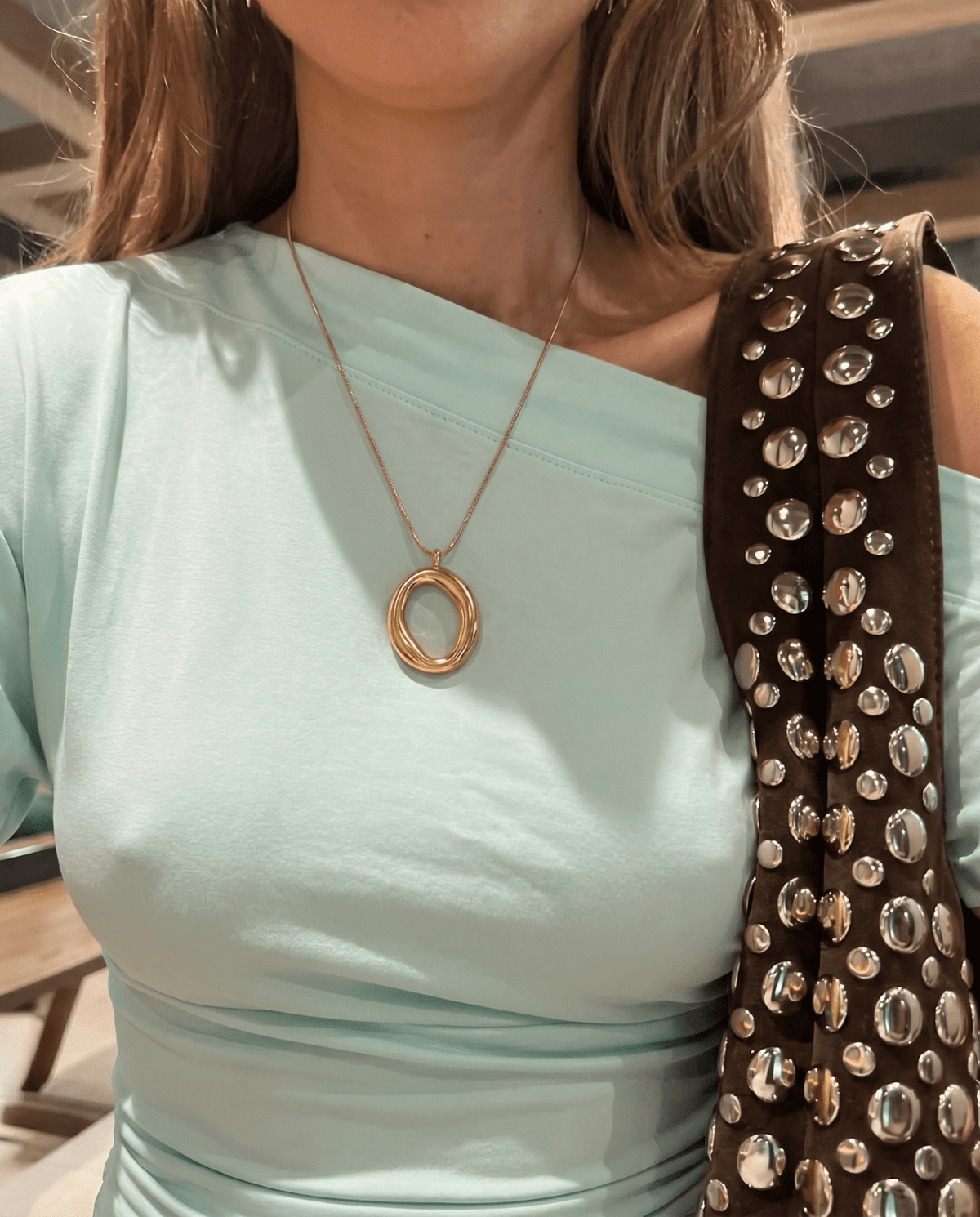 Gold-tone pendant necklace with open circle on snake chain