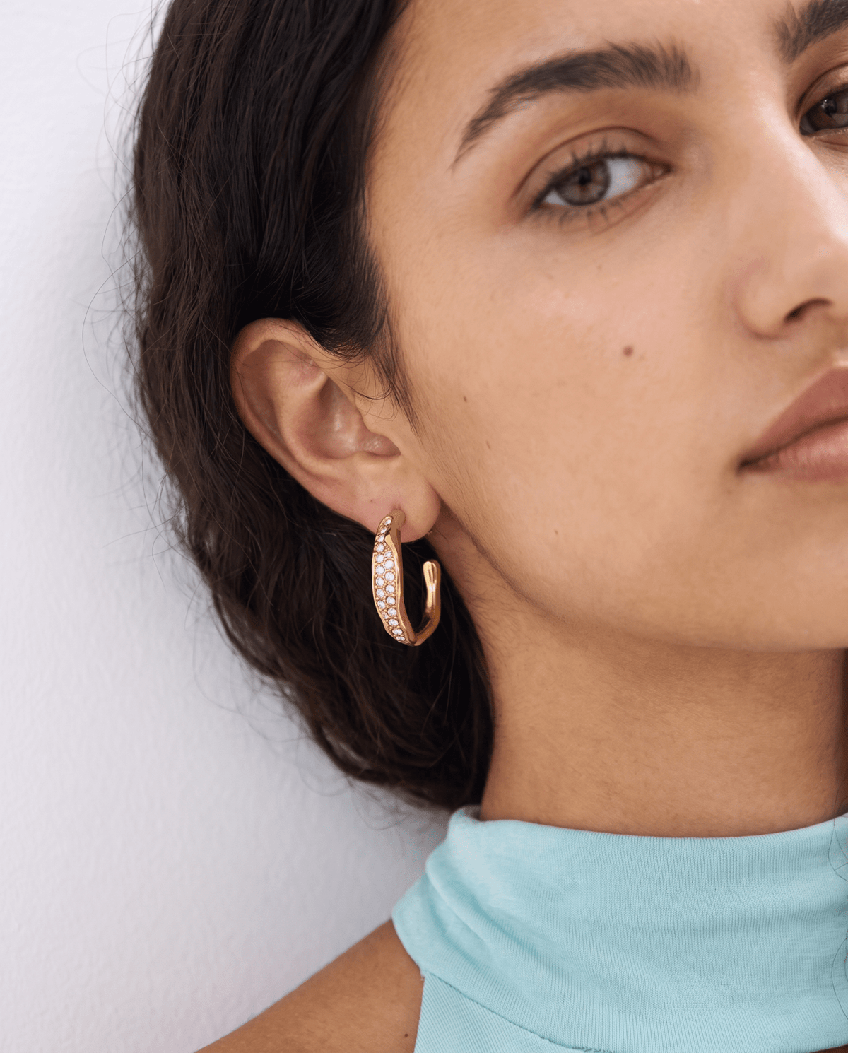 Gold-tone wavy hoop earrings with pave stones in Gold