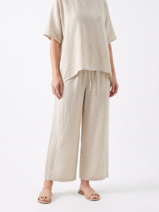 Ecru linen asymmetric top and pants set on a white background