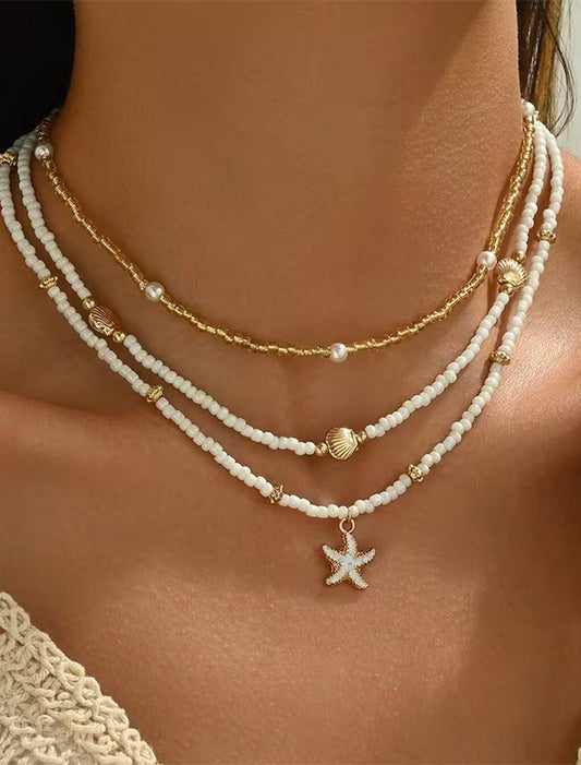 Layered beaded necklace set with shell and starfish pendants – worn