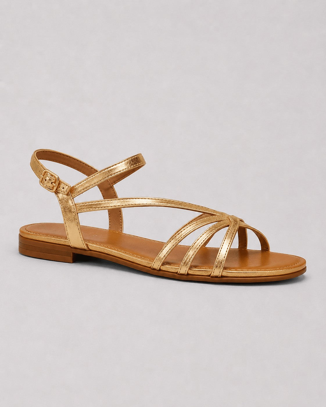 Strappy flat sandals in gold – angled