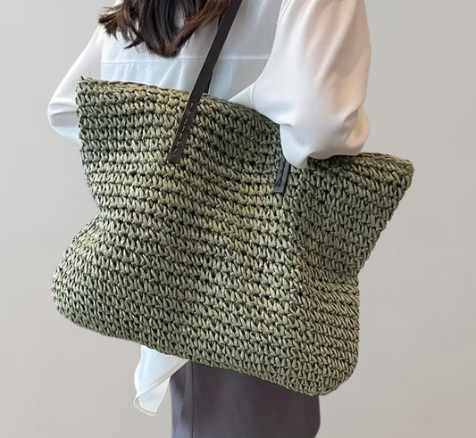 Woven straw tote bag in olive – carried on the shoulder